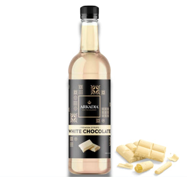 Bottle of Arkadia white chocolate syrup with white chocolate pieces on a white background